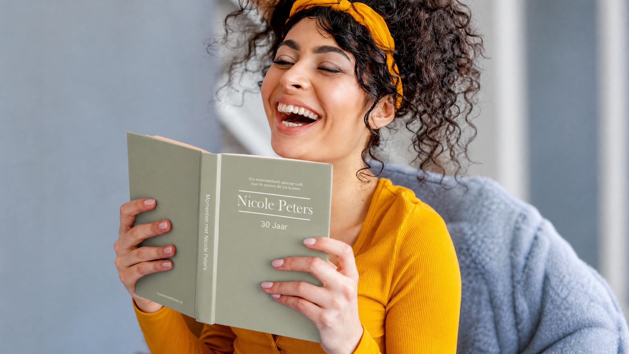 Vrouw lacht terwijl ze haar Momentenboek leest